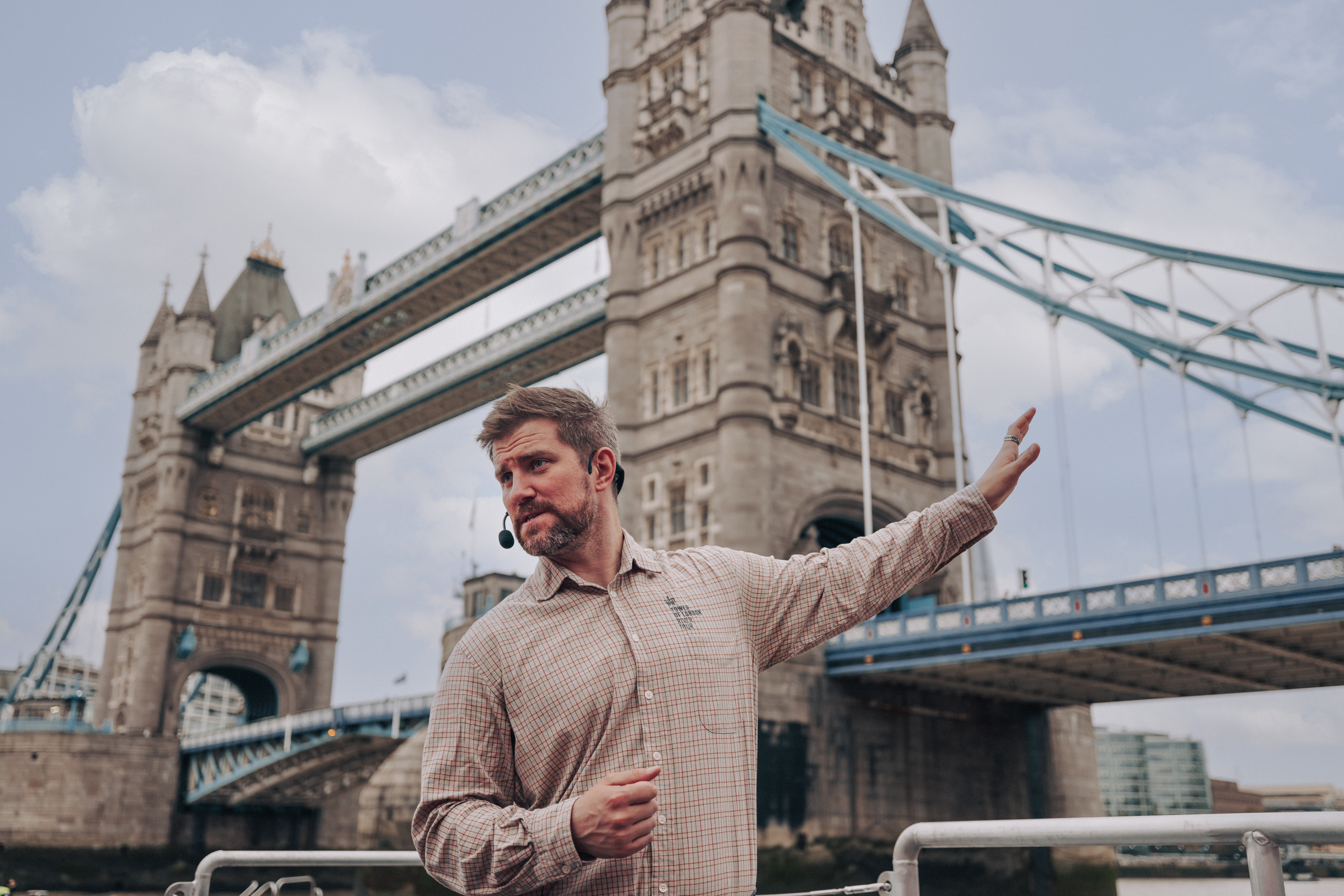 Tour guide sharing stories of Tower Bridge aboard the Tower of London River Tour